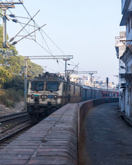 Fototapeta premium Indian Local Train Passing Through Railway Track in Urban Area