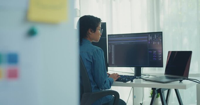 Young professional African American female programmer coding AI software on screens in modern home office. Generative AI, machine learning, digital innovation, future technology, online job concept.