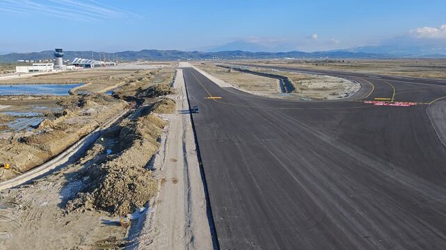 Aerial view of the new international airport under construction in Vlore Albania, a project known for repeated delays, showing unfinished runways, buildings, and large scale infrastructure development