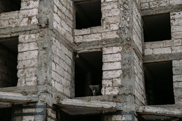 Fototapeta premium Derelict Concrete Structure With Nested Square Openings And Perched Stray Cat In Shadow, Layered Rubble And Exposed Beams, Quiet