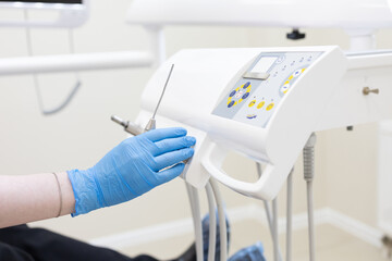 the dentist's hand puts the instrument back on the device