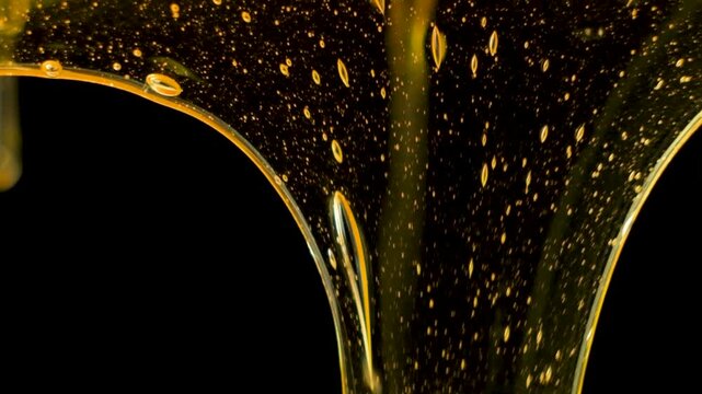 Creative Background Macro Honey Flow on Black Background Slow Motion.