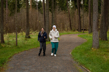 Fototapeta premium Active cancer survivor jogging with her companion in nature, showing vitality and joy during recovery. The bright outdoor setting and natural light highlight optimism, healing, and emotional balance