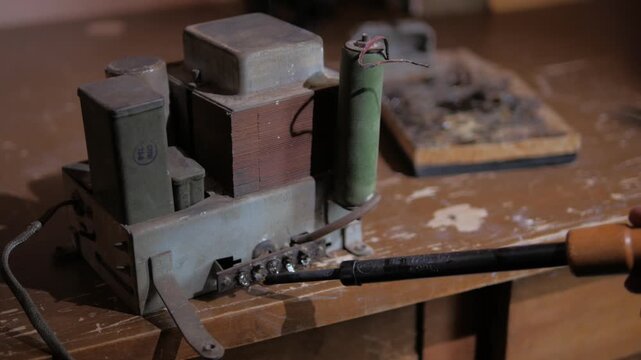 repairing contacts on an old radio amplifier using a soldering iron close-up