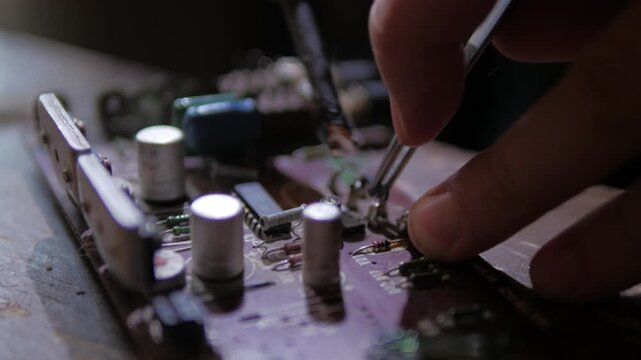 soldering a capacitor on a microcircuit radio equipment repair close-up