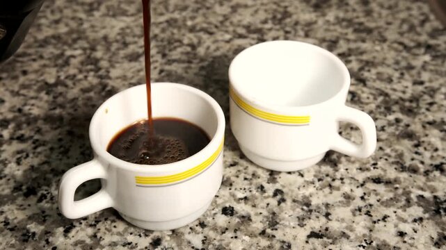 Pouring freshly brewed moka pot coffee into cups