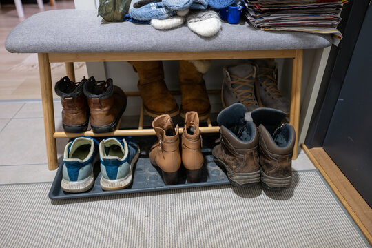 Organized shoe storage bench with winter boots and everyday footwear in cozy home hallway