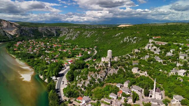 Aerial view of the medieval village Počitelj in southern Bosnia and Herzegovina. It shows the stone fortress. Narrow streets run through the village. The Neretva River flows through the valley.