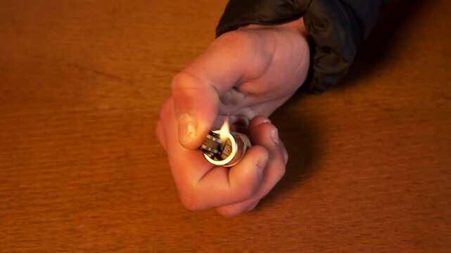 Close up of a man's hand lighting a cigarette lighter