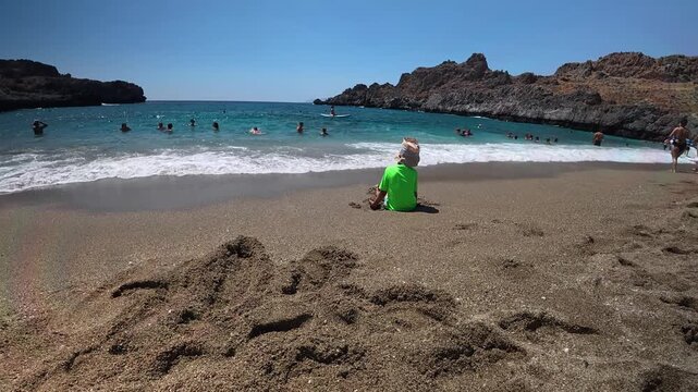Little boy are playing on the Cretan Skinaria beach