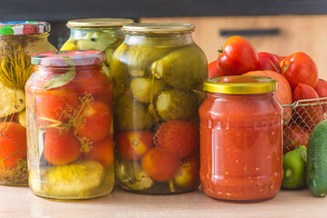 Canning jars with various vegetables on a wooden table