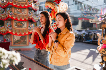 Obraz premium Young women praying at a Chinese temple in Thailand