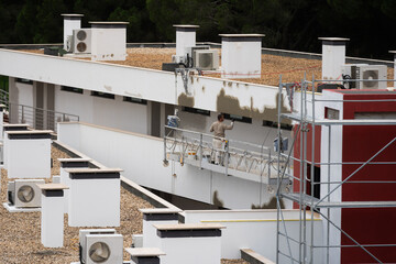 Building under renovation with scaffolding. Modern apartment balconies. Urban construction project. Restoration or exterior upgrade. Residential architecture and structural maintenance background.