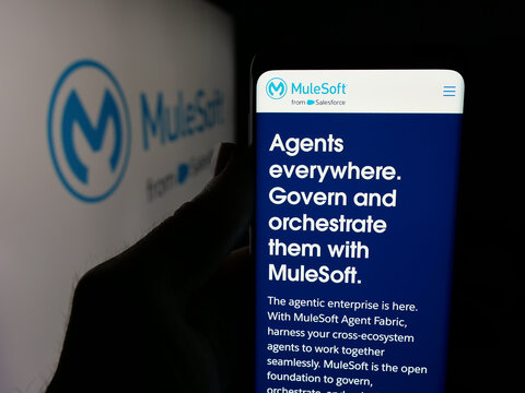 Stuttgart, Germany - 01-26-2026: Person holding smartphone with web page of US integration software company MuleSoft LLC on screen in front of logo. Focus on center of phone display.