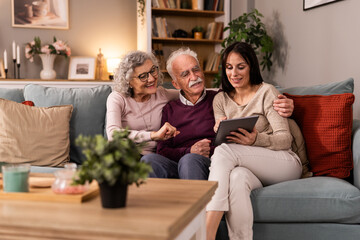 Daughter And Her Senior Parents Talking On Video CalL On Tablet