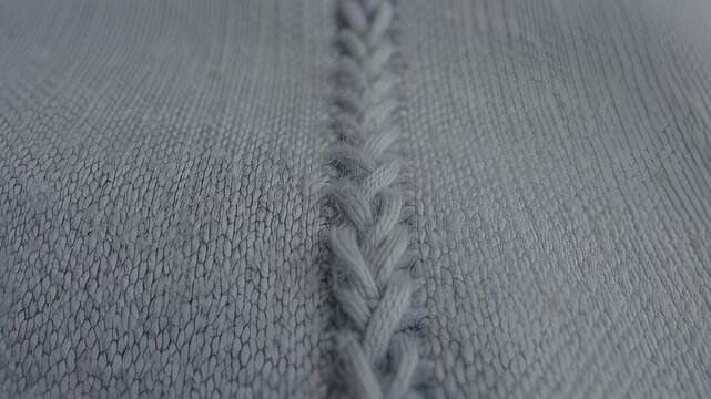 Close-up view of braided textile pattern in soft blue fabric, showcasing intricate weaving details and texture across three sequential frames of the same material, hdr video with neutral color