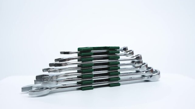 Stacked open-end spanners rotate smoothly against a white background. The video emphasizes size variation, polished steel surfaces, and professional workshop usability.