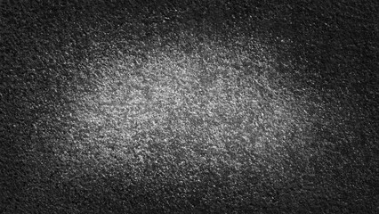 Textured black background with subtle gray gradient and light spots creating a soft, abstract surface ideal for design projects and artistic presentations