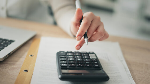 Close-up view woman's hand using a calculator