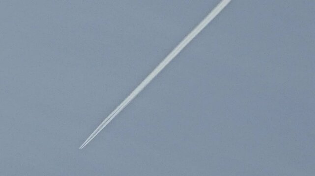 Airplane contrail against a clear sky