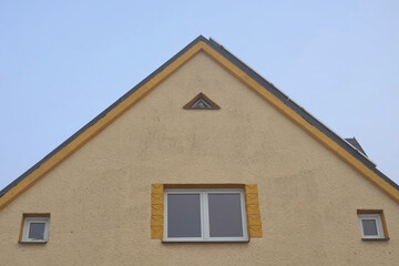 Symmetrical Architecture Detail of Yellow House Facade with Triangular Attic Window and Square Windows, Minimalist Building Exterior