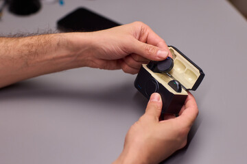 Fototapeta premium Technician handling microphone components precisely. Expert assembling tiny microphone parts with care. Closeup of technician working on delicate audio equipment setup