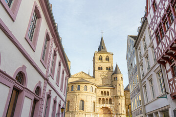 Obraz premium An ancient stone church stands out among the houses on a street in the city of Trier, Germany It's evening time