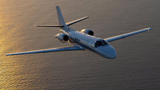 Business jet (Citation Encore ) in beautiful light sunset light, over the Pacific Ocean