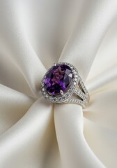 Intricately designed platinum ring showcasing a large oval amethyst gemstone accented by brilliant cut diamonds, displayed elegantly on soft white silk, sparkle, smooth, violet