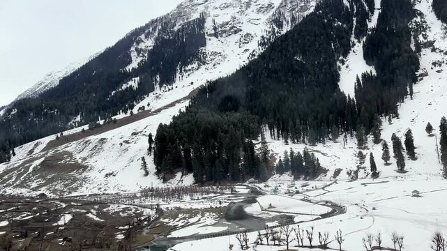 Scenic natural beauty of Chandanwari Valley featuring rocky landscapes, flowing streams, snow patches, and majestic Himalayan mountains near Pahalgam, Kashmir.