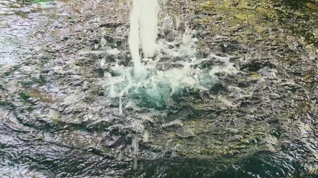 Close-up view of a bubbling water fountain or aerator within a pond.