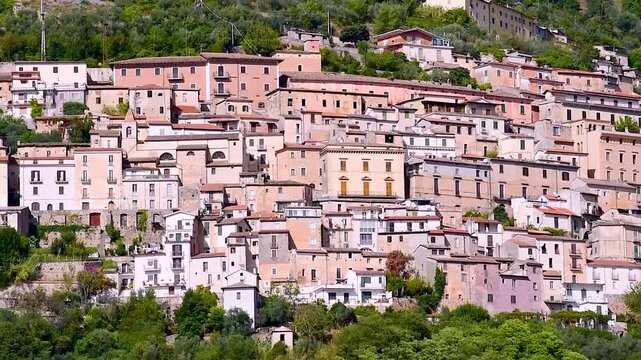 Medieval hill town of Alvito with tightly packed stone houses cascading down a green slope in the Comino Valley, amid the Italian Apennine Mountains of the Lazio region.