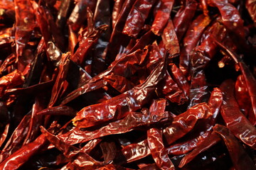 Close-up shot captures a dense pile of dried red chili peppers.