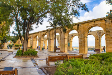 Obraz premium Colonnaded walkway with trees at the Upper Barrakka Gardens, Valletta, Malta