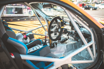Obraz premium Interior view of a race car with roll cage, steering wheel, and racing seats