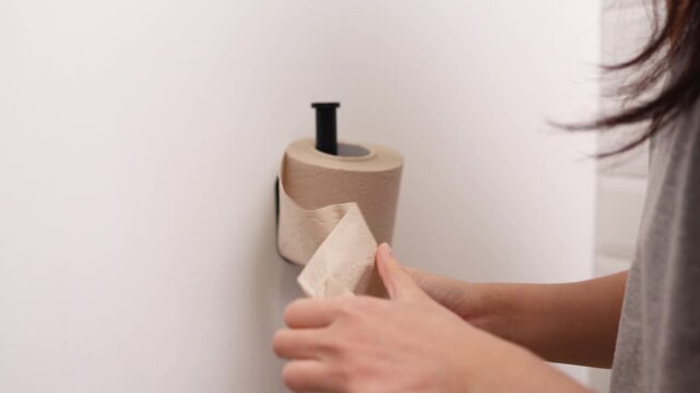 Asian woman holding toilet paper roll while sitting on toilet bowl. digestion, constipation, Diarrhea from food poisoning, infection, abdominal, stomachache, cystitis, Insurance, Health care and Medic