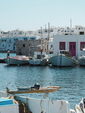 Bateaux de p&ecirc;che traditionnels amarr&eacute;s devant les maisons blanches du port de Naoussa, Paros, Gr&egrave;ce.