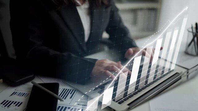 A business professional engages in financial analysis on a laptop, surrounded by modern workspace elements and digital graphs representing market trends and growth. Copula