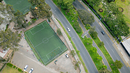 Soccer field next to a two-lane avenue seen from above.
