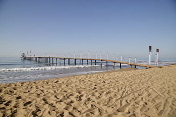 Wooden pier leading from the beach to the sea