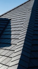 Obraz premium Modern Dark Slate Roof Texture With Crisp Shadows and Blue Sky