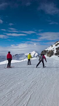 skiers on sunny ski resort slope in French Alps