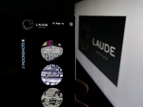 Stuttgart, Germany - 01-30-2026: Person holding smartphone with web page of computer science organisation Laude Institute on screen in front of logo. Focus on center of phone display.