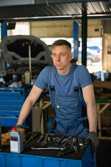 Mechanic leans on a workbench in the workshop