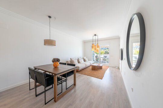 a living and dining room area in mediterranean rental home with table and sofa