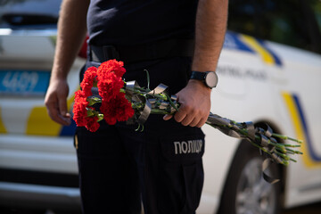 Ukrainian police officers in uniform with "Police" inscriptions paying tribute to fallen colleagues killed in the war, mourning and commemoration ceremony.