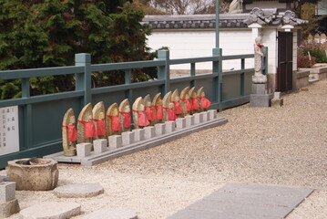 石仏が並ぶ古い寺の境内の光景