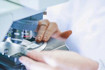 Scientific researcher using microscope for experiment analysis. Close up view of optical lenses...