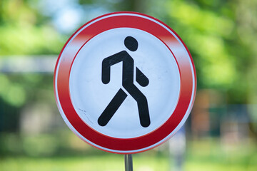 Prohibitory road sign "No pedestrians" featuring a black silhouette of a walking person inside a red circle with a diagonal slash.