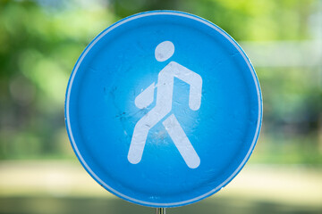 Round blue mandatory road sign "Pedestrian path" with a white silhouette of a person walking.